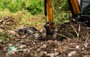 Backhoe digging soil at construction site. Bucket of backhoe digging soil. Clearing and grubbing.